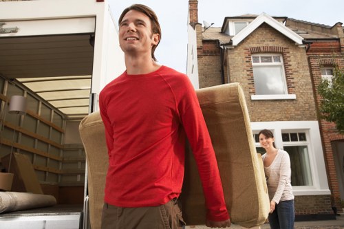 Local movers carrying furniture near a Pinner residential street